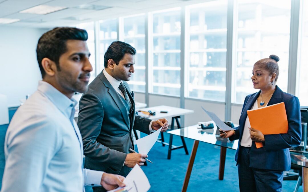 Business professionals discussing documents in a modern office environment.